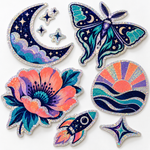 Custom die-cut glitter holographic stickers with fine multicolored sparkle and original moon, moth, flower and rocket artwork on white