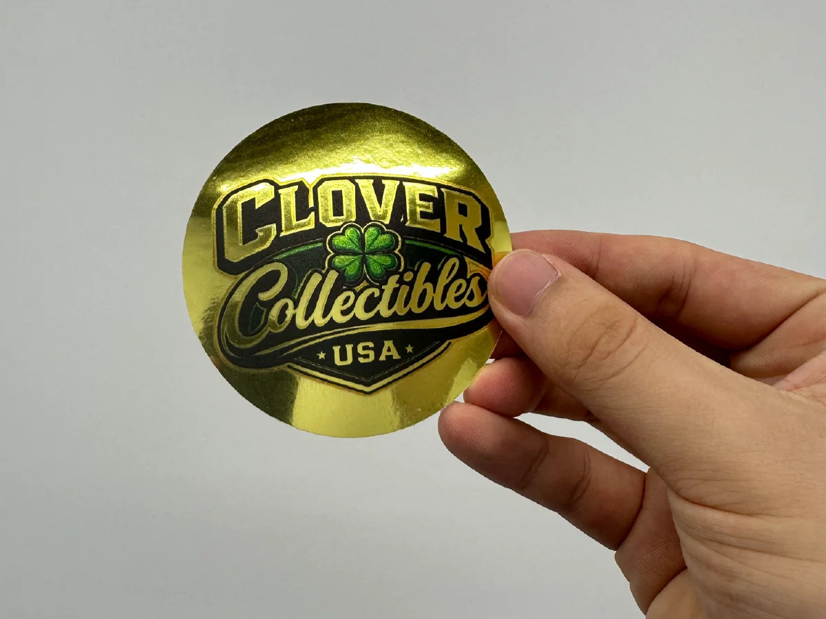 Hand holding a round metallic gold custom sticker
